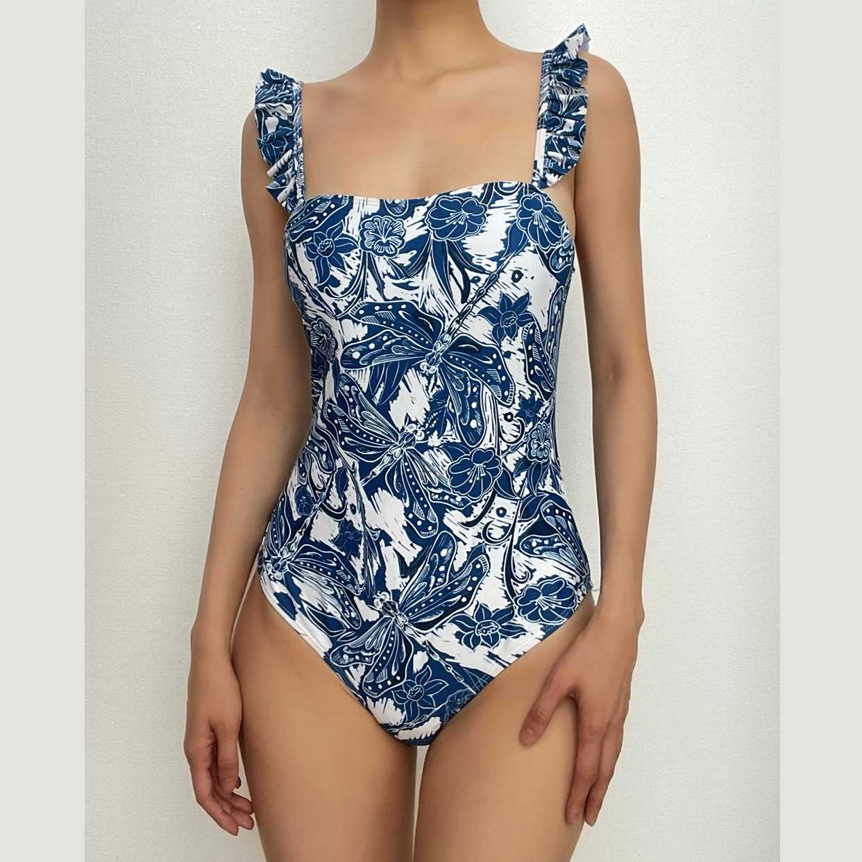 Traje de baño de una pieza con volantes y estampado abstracto en contraste con falda de playa 